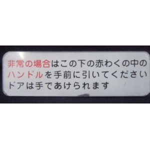 画像: プレート 「非常の場合は子の下の赤わくの中の〜ドアはてであけられます。」