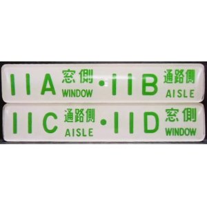 画像: 座席番号プレート（緑文字）　「１１A　窓側　・　１１B　通路側」・「１１C　通路側　・　１１D　窓側」