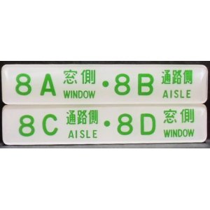 画像: 座席番号プレート（緑文字）　「８A　窓側　・　８B　通路側」・「８C　通路側　・　８D　窓側」