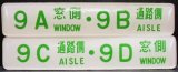 画像: 座席番号プレート（緑文字）　「９A　窓側　・　９B　通路側」・「９C　通路側　・　９D　窓側」