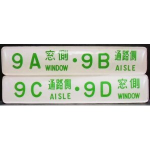 画像: 座席番号プレート（緑文字）　「９A　窓側　・　９B　通路側」・「９C　通路側　・　９D　窓側」