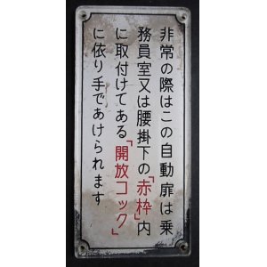 画像: 西鉄電車プレート　「非常の際はこの自動扉は乗務員室又は腰掛下の「赤枠」内に取付けてある「開放コック」に依り手でかけられます」