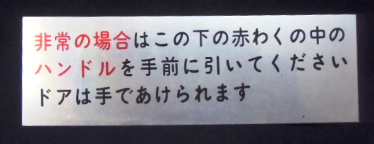 画像1: プレート　「非常の場合は、この下の赤わくの中のハンドルを手前に引いてくださいドアは手であけられます」」